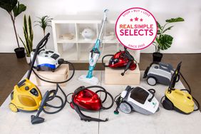 A selection of some of the best steam cleaners on a white floor in front of shelving