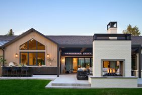 home backyard space with a bar and lounge seating around a fireplace