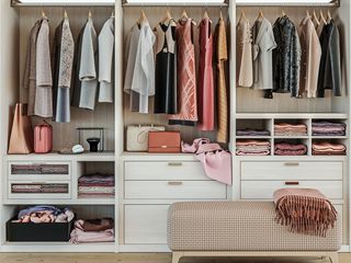 modern wooden wardrobe with women clothes hanging on rail in walk in closet design interior