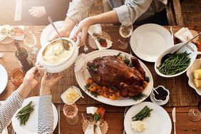 Thanksgiving Dinner on a table with turkey, corn on the cob, green beans, and mashed potatoes