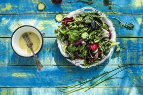 Spring salad of baby spinach, herbs, arugula and lettuce. Dressing of yogurt, olive oil, honey and lemon.