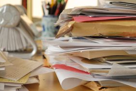 Desk full of paper clutter piles