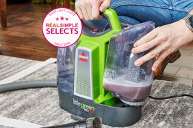 A person removing the dirty water tank from the BISSELL Little Green ProHeat Portable Carpet Cleaner