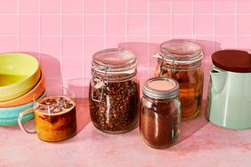 Pink counter with coffee grounds and other items in glass containers