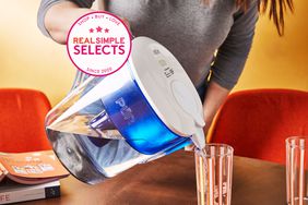 Women pouring water into a glass from the Pur Classic 11-Cup Water Filter Pitcher